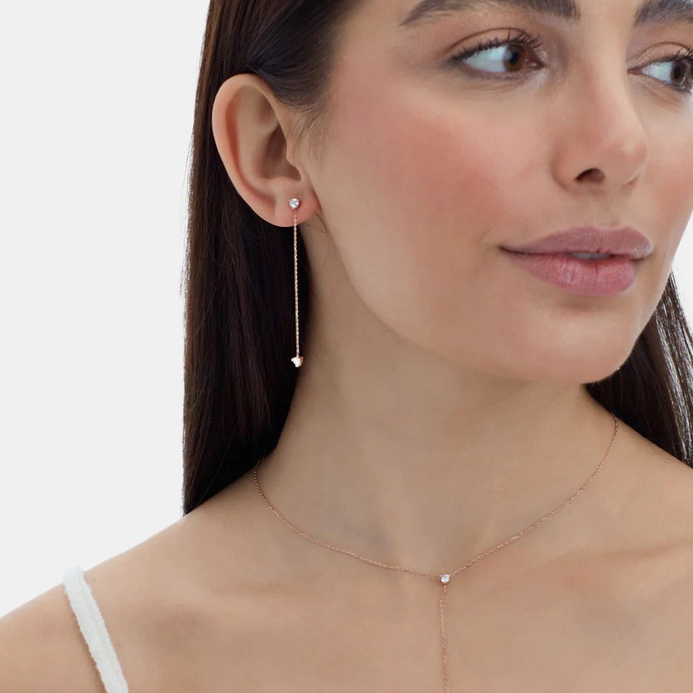 Elegant 14K gold studs feature 2 diamonds on each earring –one at the tip and one at the bottom of the chain– and 5.8mm of hanging chain that add extra dimension and a fierce style. On Model
