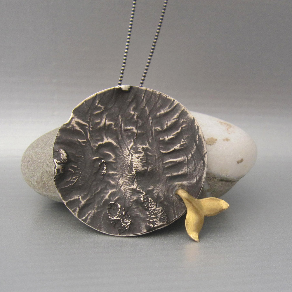 We love the bold meets activism aesthetics of this large medallion with whale tail.