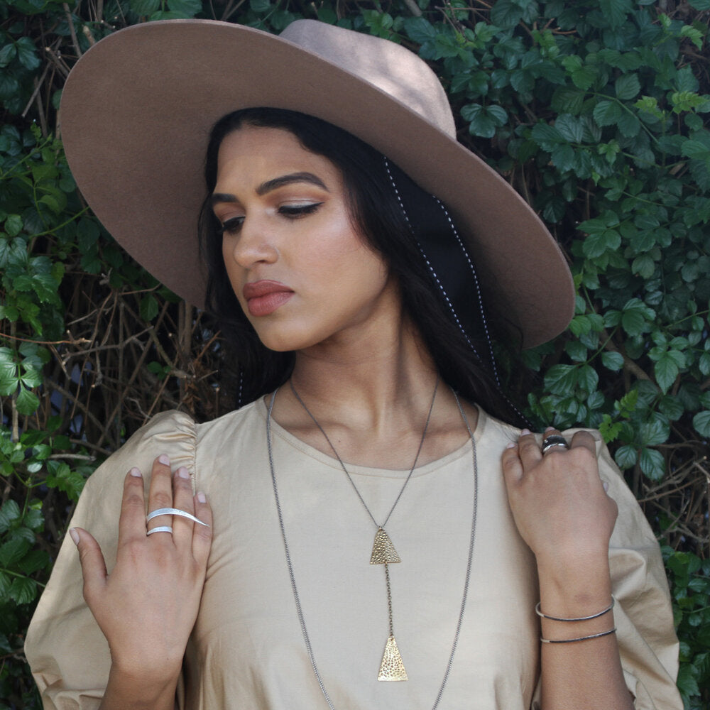 A textured dangle necklace with contrasting bronze and chain is featured in this fish y chain necklace. Designer Maddalena Bearzi always finds innovative ways to translate nature into her jewelry collection.