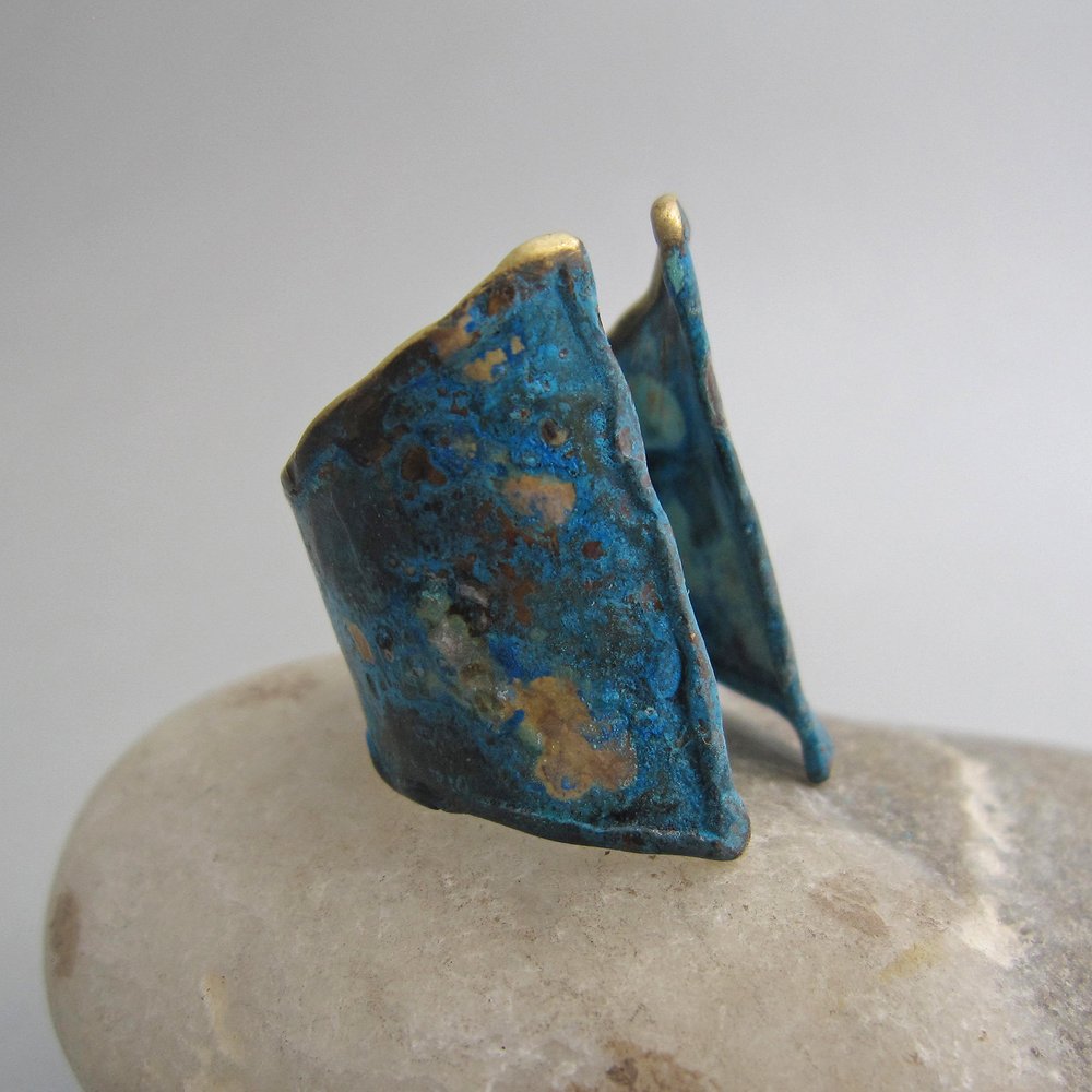 A tall slope of golden earth inspired Maddalena Bearzi in the creation of this unique and easy to wear adjustable wide band that makes a bold statement. In this version, Maddalena altered the design with blue reflections as on the water surface.