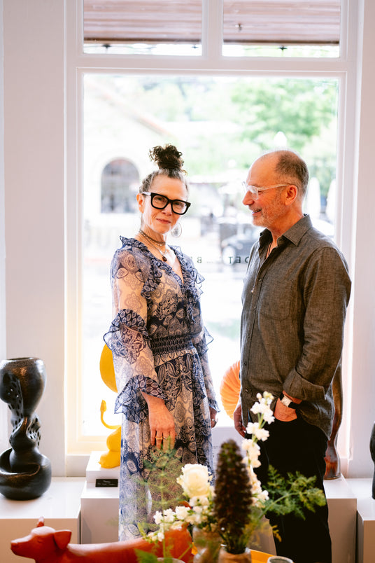 Founders Bonnie Powers and Jeffrey Levin standing in their art and design gallery in front of the window facing The Depot Plaza
