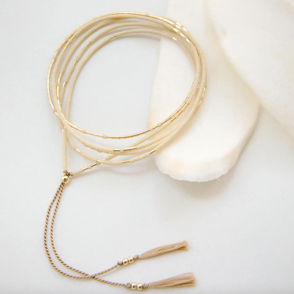 The Neso in Oyster is a convertible necklace to wrap bracelet made with matte glass beads and gold beads. Designed for versatility and function, it layers and stacks perfectly as both a necklace and a bracelet