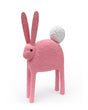 Pink rabbit ceramic sculpture with a white fluffy ball tail 