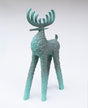 A stylized deer sculpture with textured, surfaces and large antlers, painted in a muted ombre teal-green color.