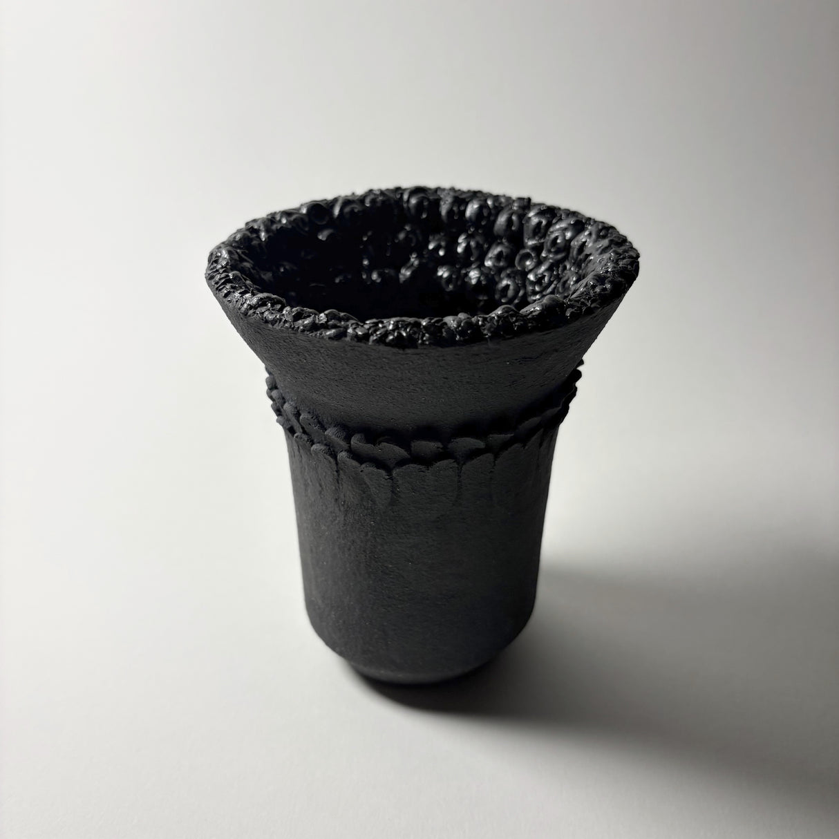 Dark Holding Vase in black clay  with intricate details inspired by the resilient plants of the desert, their forms and textures