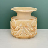 Wheel thrown vase with hand carved relief flower designs. In natural glaze. 