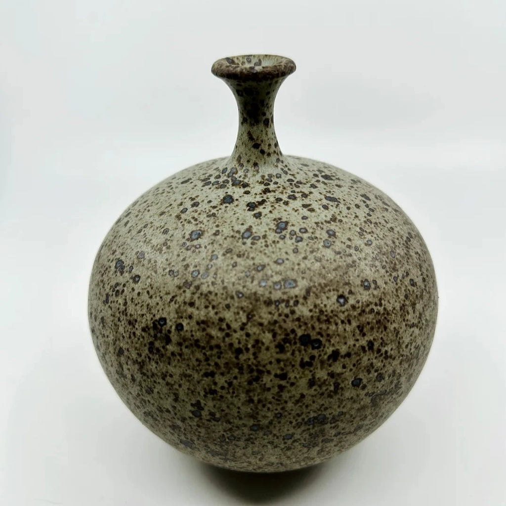 A little neck bottleneck by Dana Chieco. Her bottleneck forms are a gorgeous take on this distinct style. This petite vase is a deep speckled clay with blue and pistachio glazed tones. 