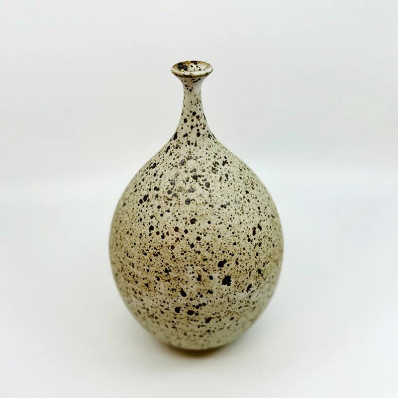Dana Chieco wheel-thrown deep speckled bottleneck vessel glazed in matte white. Handmade from stoneware, this piece serves as a testament to the timeless beauty of heirloom pottery, bringing an organic serenity to your dearest spaces.