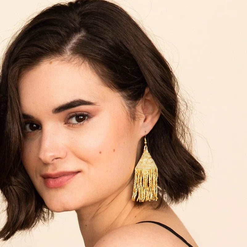 Lexie Woven and Beaded Earrings in a Solid Color Way of Shimmering Gold shown on model