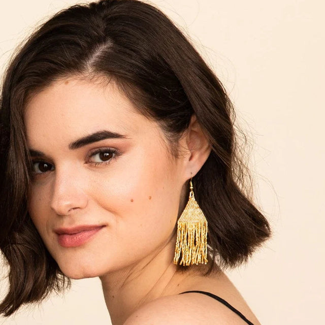 Lexie Woven and Beaded Earrings in a Solid Color Way of Shimmering Gold shown on model
