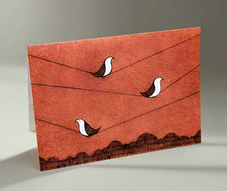 Greeting card with three birds on wire and mountains below. 