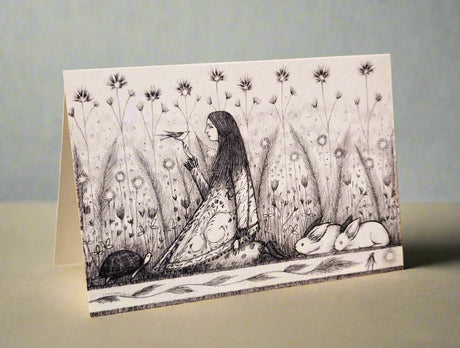 Illustrated card with a woman sitting among flowers and animals 
