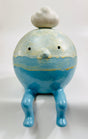 A ceramic figurine of a seated blue cloud man character with a small white cloud on its head, glazed in various shades of blues and white and with yellow accents.