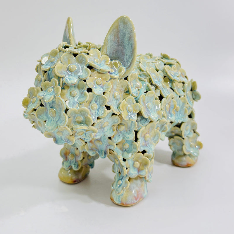This is Honey Dew, a standing ceramic Frenchie dog sculpture in iridescent light mint green glaze.