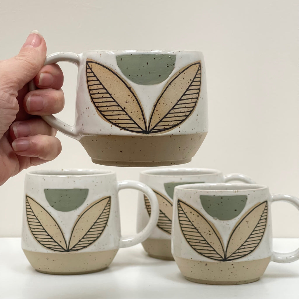 This substantial beauty of a ceramic mug by Julems Ceramics comes in 14oz to hold your favorite beverage or soup. We love the pop of color with a flower pattern in a green palette.