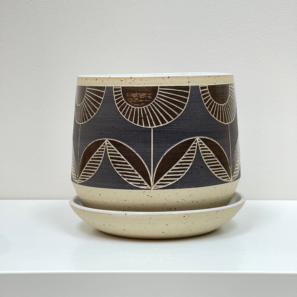 Julems wheel thrown large planter and saucer creates height and mix and match delight with its geometric hand carved flowers design. The rich glaze achieves a sublime visual impact.