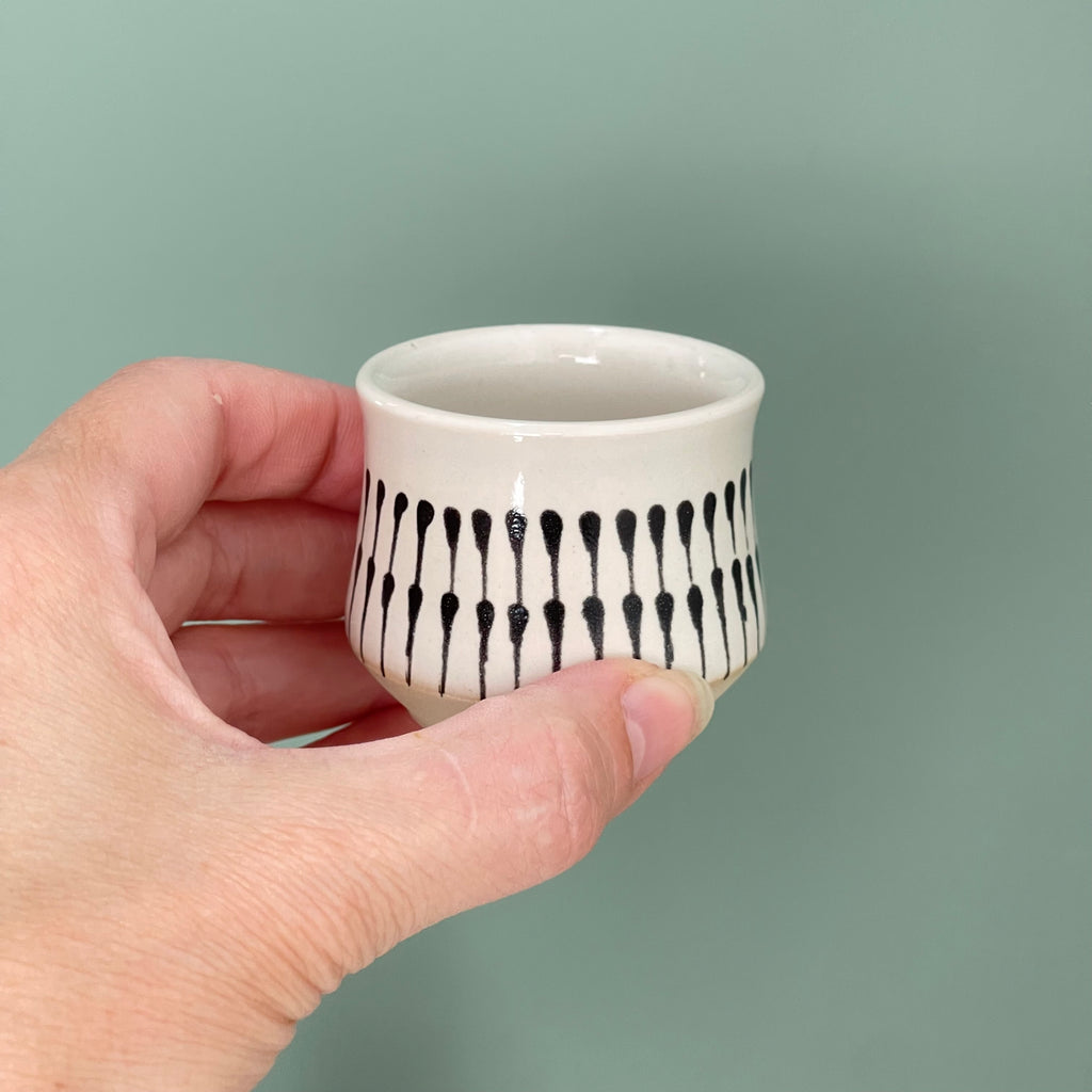 Handmade sake cups or espresso cups, with different decorative techniques. 1. teardrop pattern using black underglaze on top of the white glaze.