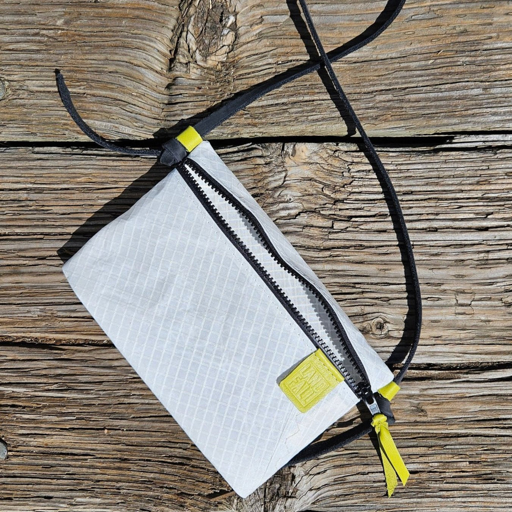 The sacoche is a lightweight, durable crossbody or shoulder bag for everyday. In white sail cloth with black leather strap.
