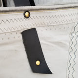 An open sail cloth bag handmade in Sausalito from upcycled sails. Black leather handles and detail. 