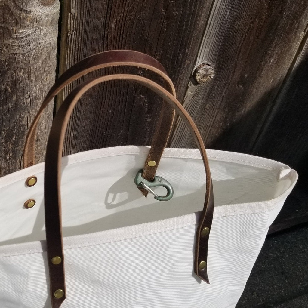 Tote bags instead of plastic bags! Use these Landfall Leatherworks Provisioner open sail cloth bags to carry your farmer's market haul, swim suit and towel, beach reads and sketchpads. With Natural Leather handles and key clip.