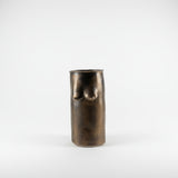 Bronze vase with breast forms on a plain background