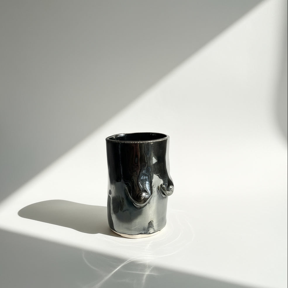 Shiny chrome glazed tittie cup or vase on a white background