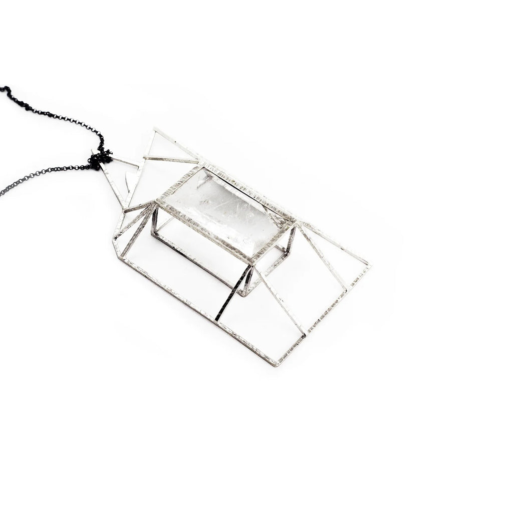 A rough-hewn rock crystal is suspended in an architecturally driven bold setting. A sublime statement necklace where industrial and artistic design meet. Side view