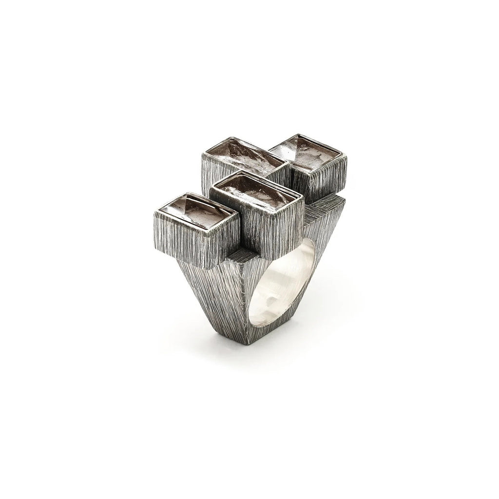 Catch rays of light with this fiercely big rough-hewn crystal ring. Etched and oxidized silver settings of differing heights and alternating position to one another encase four natural faced rock crystals.