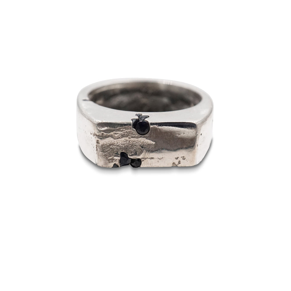 A signet ring made from hand poured molten silver that is sand cast in a mould with natural sapphire gems. 