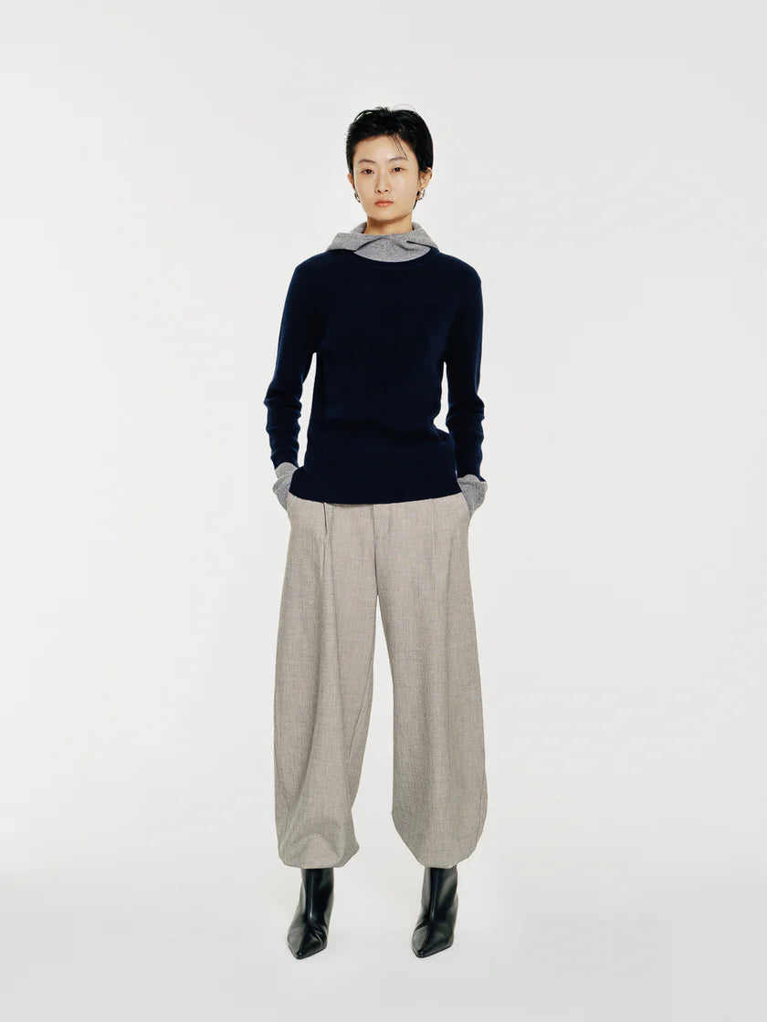 The Linden sweater by Mute by JL is crafted from 100% wool and features a soft mock neck that transitions into a draped hood for both function and form.