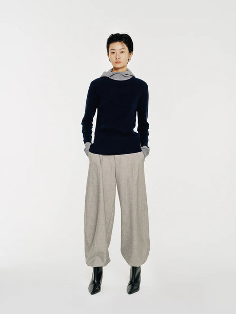 The Linden sweater by Mute by JL is crafted from 100% wool and features a soft mock neck that transitions into a draped hood for both function and form.