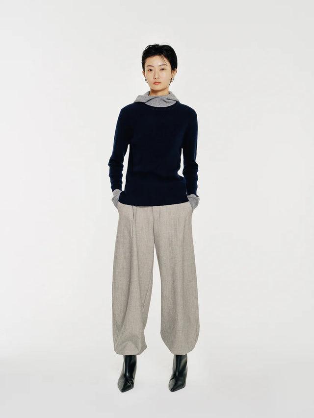 The Linden sweater by Mute by JL is crafted from 100% wool and features a soft mock neck that transitions into a draped hood for both function and form.