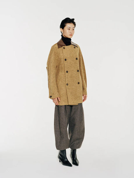 This double-breasted coat wool coat with contrast collar and ever so slightly avant garde curved sleeve seam lines