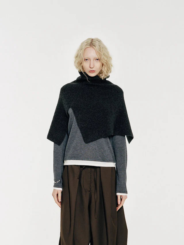 The neck warmer is a versatile piece that can be worn over coats, shirts, and sweaters. Crafted from soft, high-quality merino wool, it features a refined rib-knit texture, turtle neck, and elegantly drapes over the shoulders. By Mute by JL