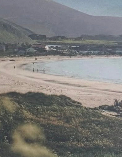 Collage landscape with mountains, ocean, and a cut paper sun in the sky.