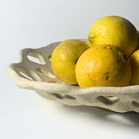 Avigail Remak Shallow Holey Bowl with lemons from the Desert Rising collection, Avigail Remak is inspired by the resilient plants of the desert, their forms, textures, surprising variety, and their tough defenses of spikes and thorns. 