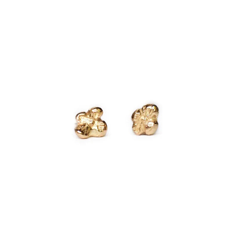The Idun petite is a mini four petal 14K yellow gold flower stud earring. Hand-carved and lost wax cast in 14K fairmined gold by Northern California jeweler Siri Hansdotter.