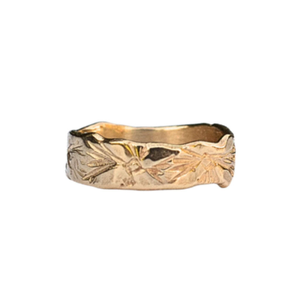 Hand carved with petal flowers, this unisex flat band in yellow gold can be worn by the groom and bride as an alternative wedding band. It's also a great layering ring with other rings or a stacking band to add texture.