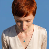 Model wearing blue topaz pendant on chain