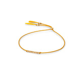 A delicate plantain yellow silk cord bracelet featuring a central cluster of small 14k gold filled beads and adjustable plantain yellow tassel ends, displayed on a clean white background.