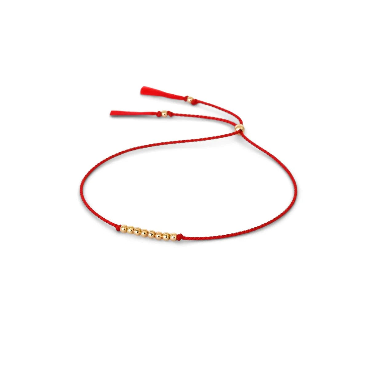 A delicate red silk cord bracelet featuring a central cluster of small 14k gold filled beads and adjustable red silk tassel ends, displayed on a clean white background.