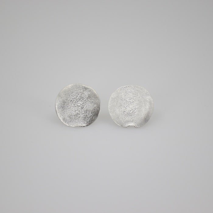 Hand fabricated sterling silver stud earrings. Esther Metals gives it a torch texture for a more atmospheric feel and it's finished in a bright silver patina.