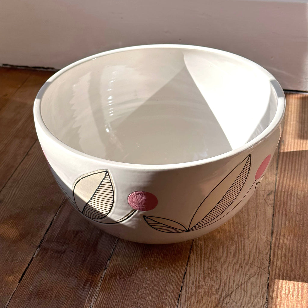 Scandinavian-folk inspired large fruit, salad and pasta serving bowl. We love the pop of color with a flower pattern in a pink palette. This 10" bowl is wheel thrown, glazed and decorated by hand. Top view.