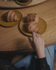 Carina Hardy Pearl Solo Solitaire Ring  in 22K Gold Vermeil on Model sitting in a cafe eating a croissant and drinking coffee