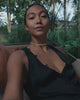 Video of a woman wearing a choker necklace made of a succession of gold lily pads in the form of a choker necklace