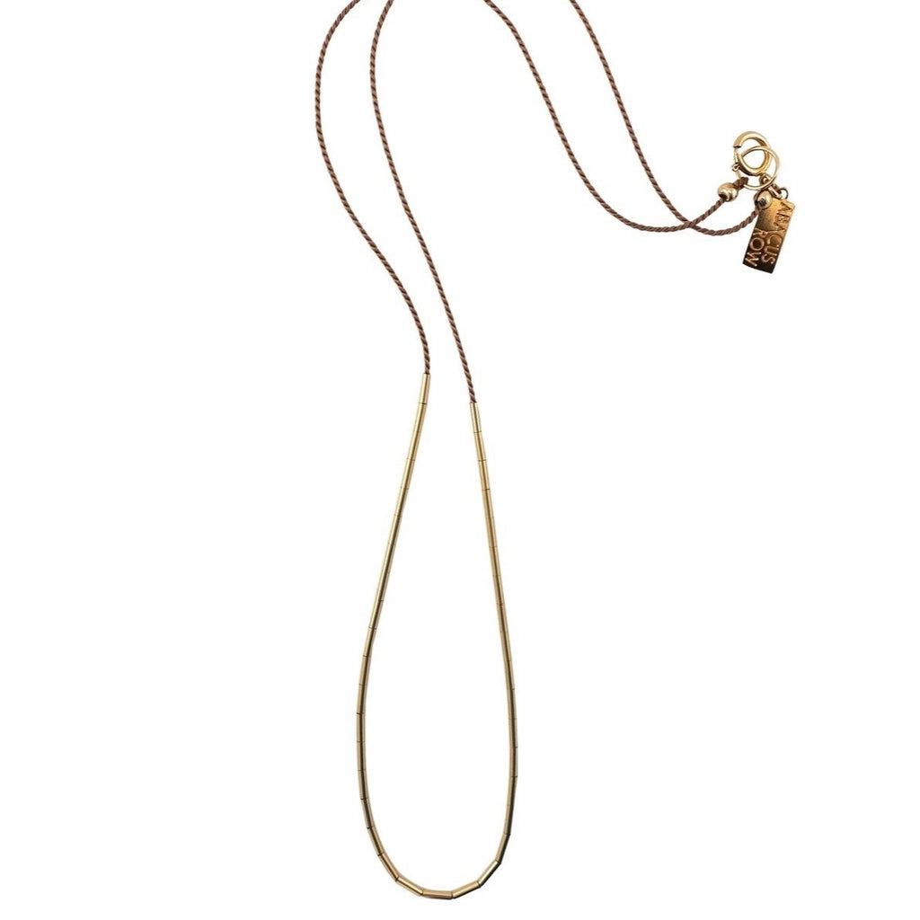 The Circinus is simple and elegant with a dash of color and gold. The tubes on this necklace can be redistributed to create a continuous arc or a smattering of gold by gently moving the beads around where you want them placed.