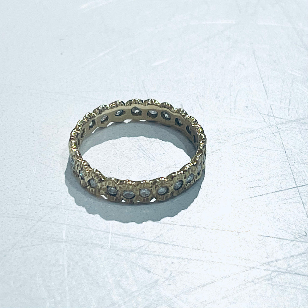 Add texture to your ring stack or wedding ring with this stunning textured yellow gold looped eternity diamond band. 