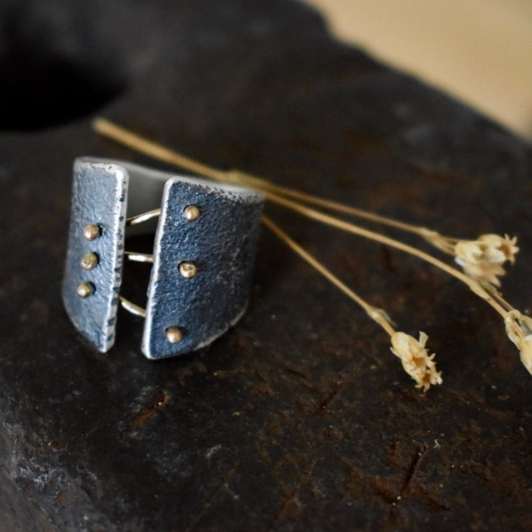 We love Esther Metal's Binding Light collection, with its corseted use of 14k torch formed rivets that bind the oxidized silver ring.