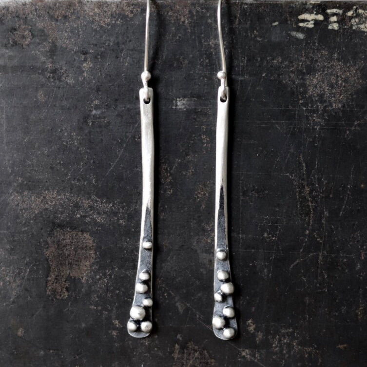 These long sprout earrings in sterling silver by Esther Metals are sublime for day to night with their oxidized granulation seed orbs settled at the base.