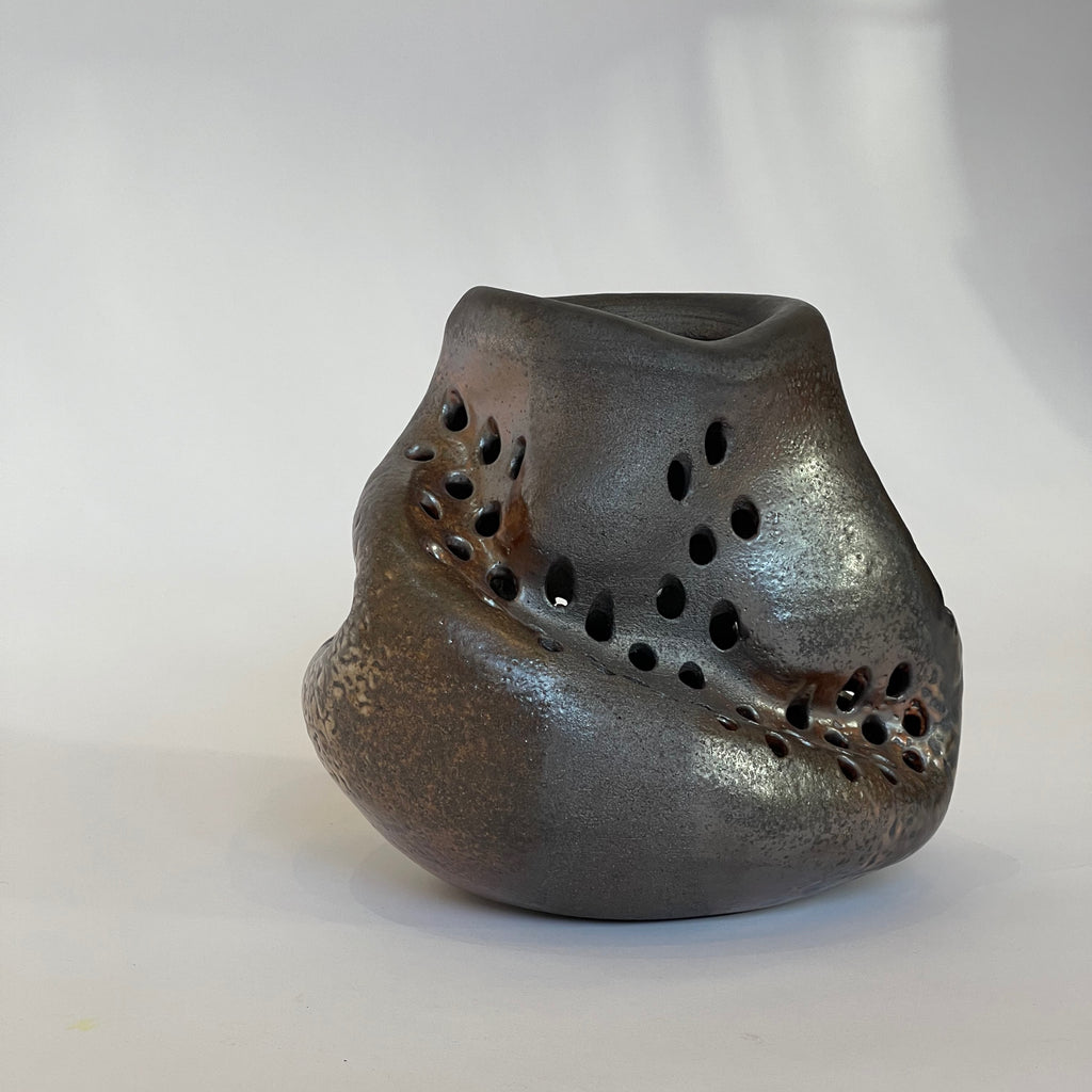 This one-of-a-kind wood fired black wave vase by Ian Hazard Bill has a gorgeous metallic glaze and drilled holes. Hazard Bill_Vase_Wave_med_127_1